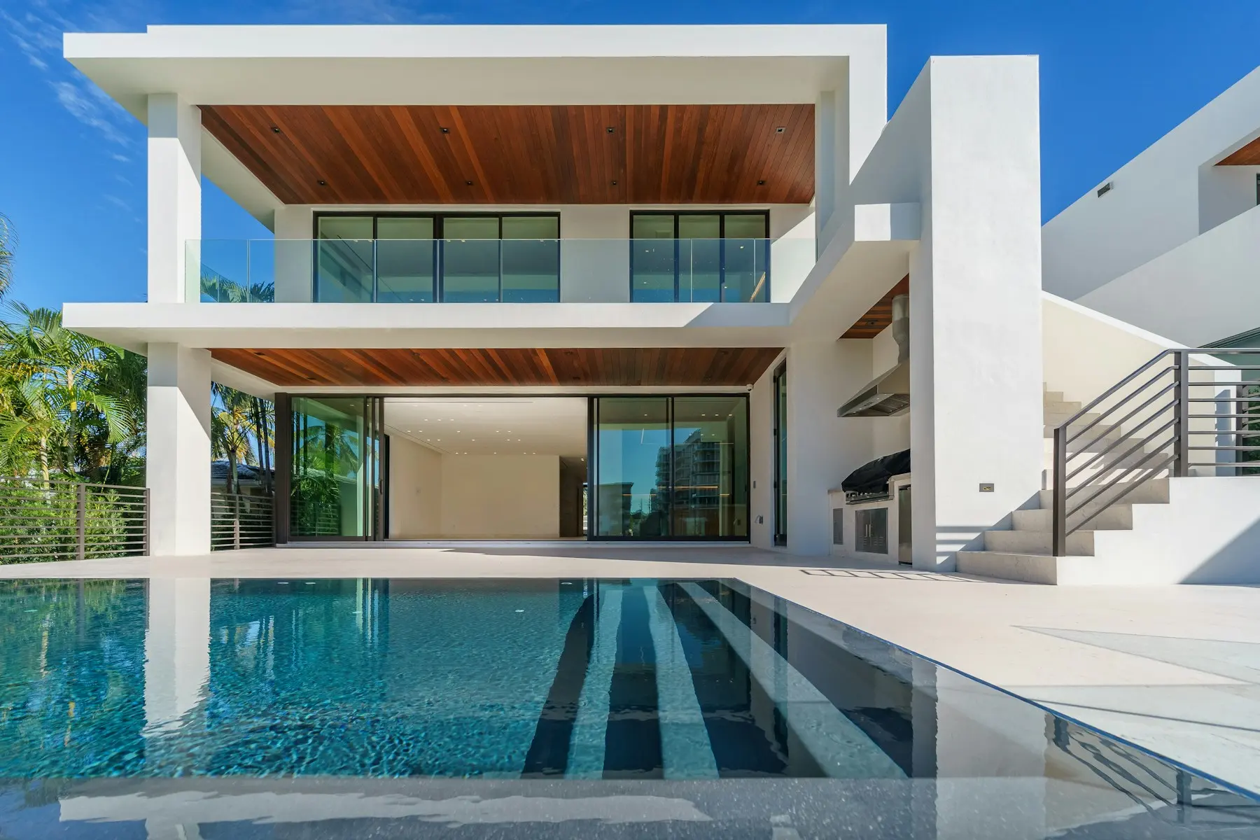 Casa branca de dois pavimentos com piscina e varandas em madeira
